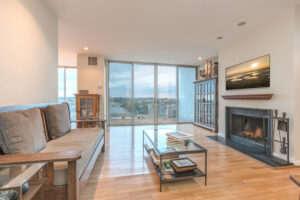 living room fireplace and floor to ceiling windows with view of river